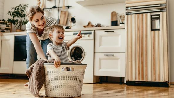 Mutter und Kind am Wäsche waschen