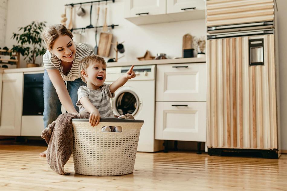 Mutter und Kind am Wäsche waschen