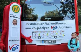 VOS-Maskottchen Haltelinchen und die Jungkünstlerin Carla von der Grundschule Glandorf vor ihrem „Bus-Kunstwerk“ 