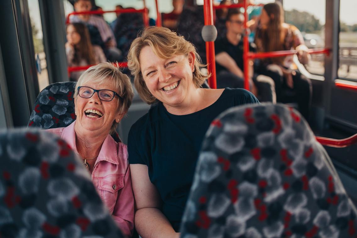 Zwei Lehrerinnen sitzen lächelnd im Bus der VOS