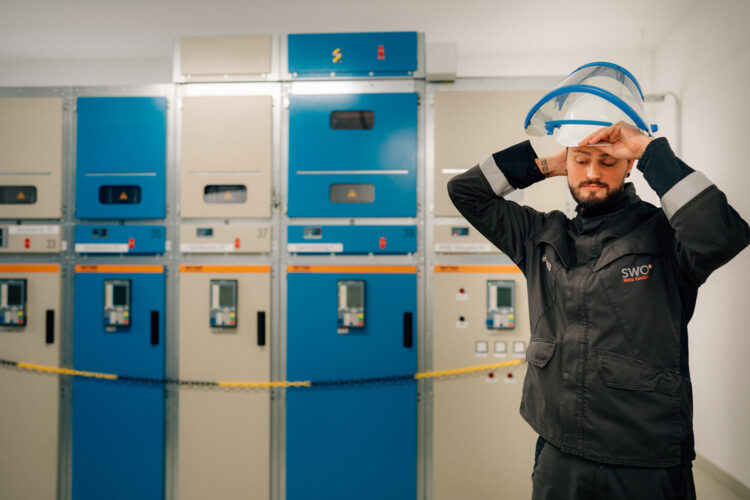 Mitarbeiter im Schalthaus legt Arbeitskleidung an.