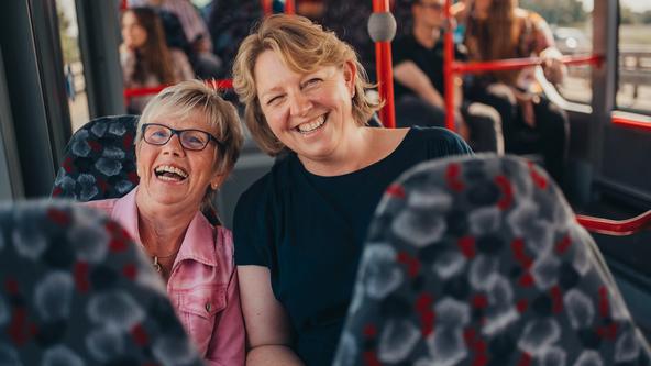 Zwei Lehrerinnen sitzen lächelnd im Bus der VOS